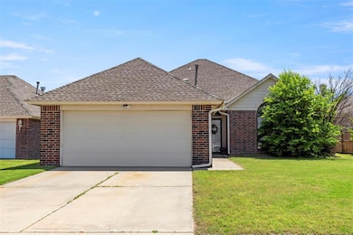 View of front of house with brick siding, a garage, a shingled roof, a front yard, and concrete driveway