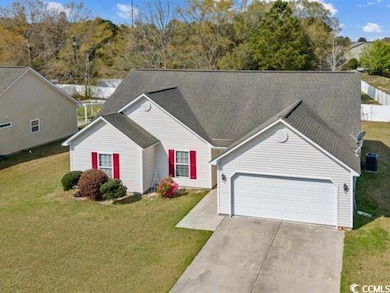 View of front of house with a front lawn, concrete driveway, and roof with shingles