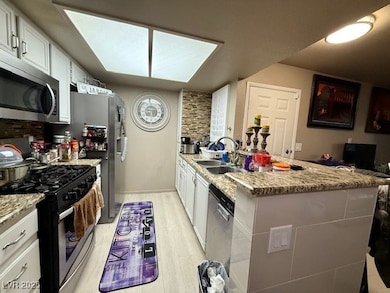 Kitchen featuring light stone counters, stainless
