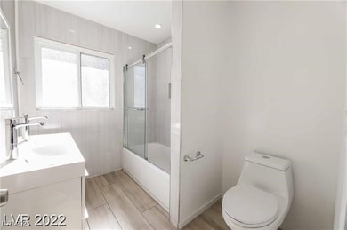 Full bath with toilet, vanity, wood finished floor
