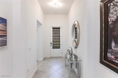 Entryway with light tile patterned floors and baseboards