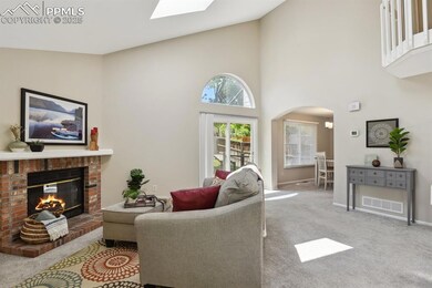 Living room featuring arched walkways, a fireplace, carpet flooring, baseboards, and a high ceiling