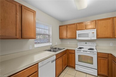 Kitchen with window above sink, white appliances, 
