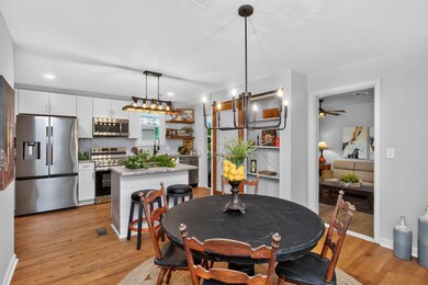 Kitchen and dining room with white cabinets, island, stainless steel appliances, hardwood floors. - 900 Vantrease Rd, Madison, TN 37115