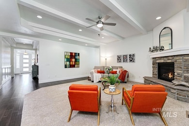 Living area with a ceiling fan, a fireplace, beamed ceiling, recessed lighting, and wood finished floors