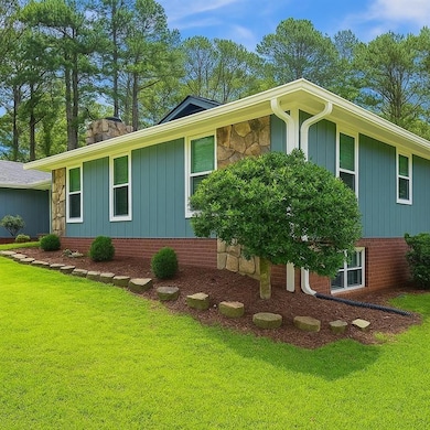 View of side of home with board and batten siding, a yard, and stone siding