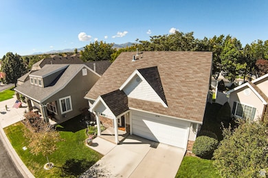 View of front of home featuring roof with shingles, driveway, a garage, and stone siding