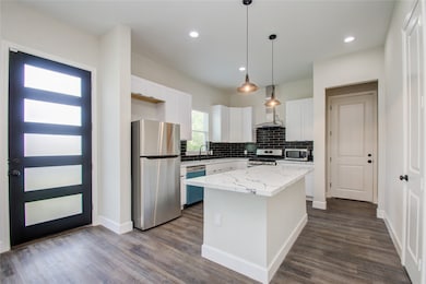 The breakfast bar divides or connects the kitchen to the living room and dining area