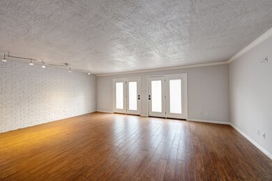 Empty family room with brick wall/ French doors to