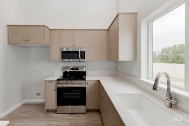 Kitchen featuring stainless steel appliances, light wood-style floors, modern cabinets, and light brown cabinetry