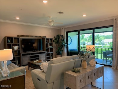 Tiled living room with ceiling fan and crown molding