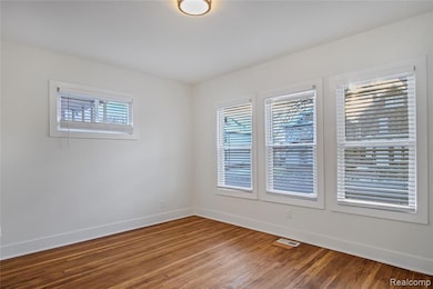 Empty room featuring wood finished floors and baseboards
