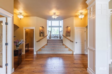 Foyer entrance with hardwood / wood-style floors, stairs, and a textured ceiling