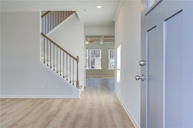 Foyer featuring beamed ceiling, light hardwood / wood-style flooring, ceiling fan, ornamental molding, and coffered ceiling
