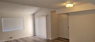 Unfurnished bedroom with a textured ceiling, wood