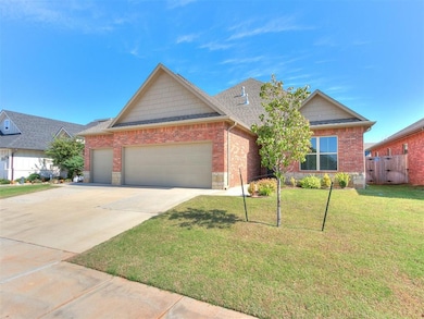 View of front of house with an attached garage, driveway, roof with shingles, and brick siding