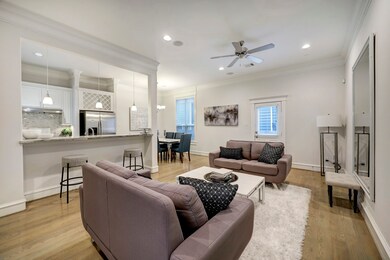 Throughout the main floor, traditional elements such as crown molding and wood floors are combined with modern elements such as crisp white walls and recessed lighting.