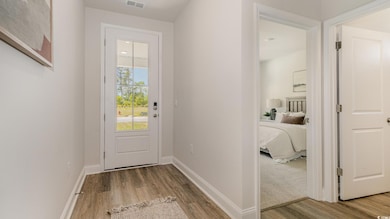 Doorway to outside with wood finished floors and baseboards