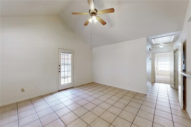 Empty room featuring attic access, ceiling fan, light tile patterned flooring, and high vaulted ceiling
