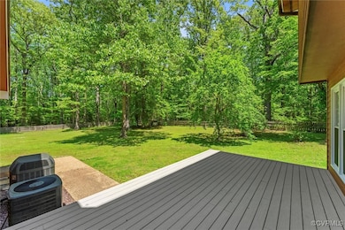 Wooden terrace with a lawn, cooling unit, and a fe