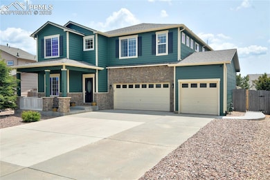 View of front of home with covered porch, driveway, stone siding, a 3 garage.