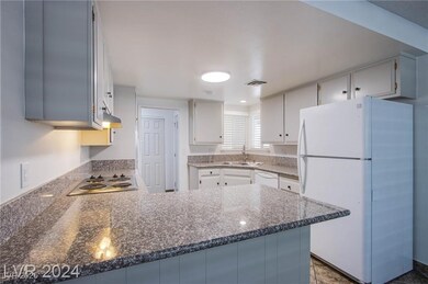 Kitchen featuring a peninsula, white appliances, a