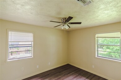 Empty room with dark wood-style floors, ceiling fa