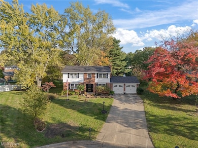 View of front of house with a front yard, driveway, and brick siding