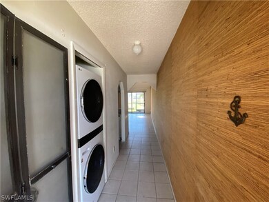 Laundry room with light tile floors, stacked washi