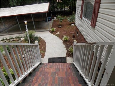 Brick steps and concrete walk down to the carport.