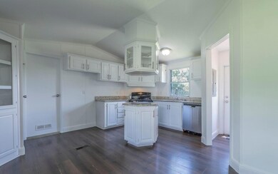 Kitchen with a center island, white cabinetry, da