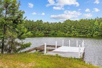 Dock featuring a water view and a view of trees