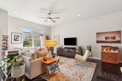 Living room with ceiling fan and dark hardwood / wood-style floors
