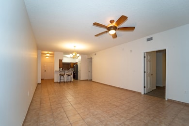 Unfurnished living room with a chandelier, ceiling fan, a textured ceiling, and light tile patterned flooring