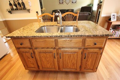 Granite island with bar seating in kitchen. 