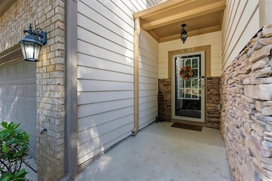 Entrance to property featuring a garage and stone siding