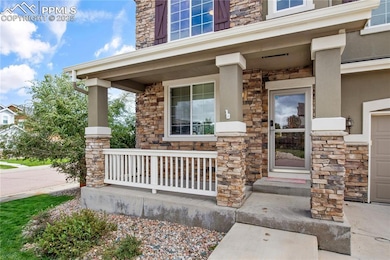 Property entrance featuring stone siding, a porch, and stucco siding