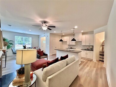 Living room featuring light wood-style floors, a ceiling fan, recessed lighting, and baseboards