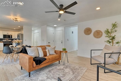 Living room featuring recessed lighting, light wood-style flooring, and a ceiling fan
