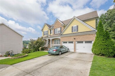 Traditional-style home with brick siding, driveway, a front lawn, an attached garage, and a porch