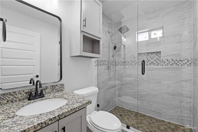 Bathroom with toilet, walk in shower, and vanity