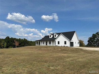 View of front of property with a porch, a front yard, and driveway