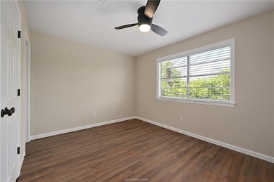 Spare room featuring ceiling fan and dark wood-typ