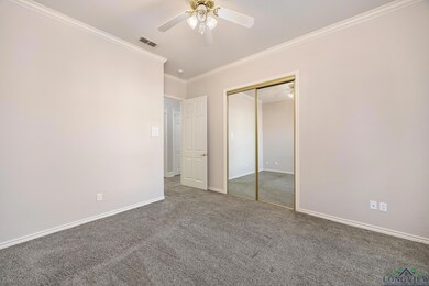 Unfurnished bedroom with ceiling fan, a closet, carpet floors, and ornamental molding