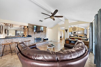 Den offers a wet bar and open floor plan through to the kitchen