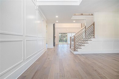 Foyer entrance featuring a decorative wall, stairway, light wood-type flooring, and recessed lighting