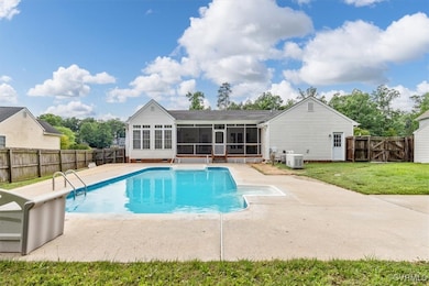 View of swimming pool featuring a sunroom, central