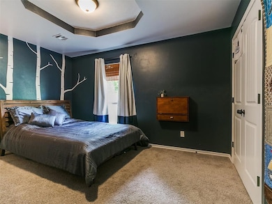 Bedroom featuring carpet flooring, baseboards, and