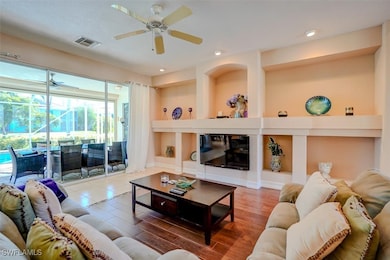 Living room with wood-type flooring and ceiling fa