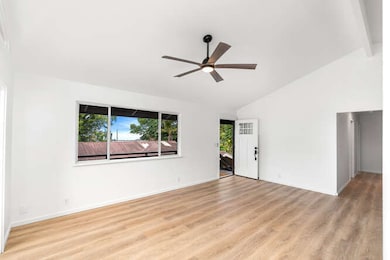 Front Door Leading to Living Room w/ Vaulted Ceiling & Hallway to 3 Bedrooms and 2 Bathrooms